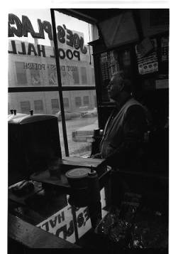 A man looks out the window of Joe's Place Pool Hall